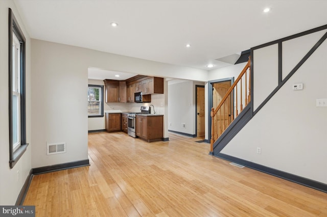 kitchen with light hardwood / wood-style flooring and stainless steel gas range