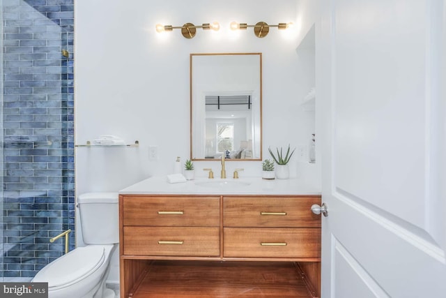 bathroom featuring vanity, a shower, and toilet