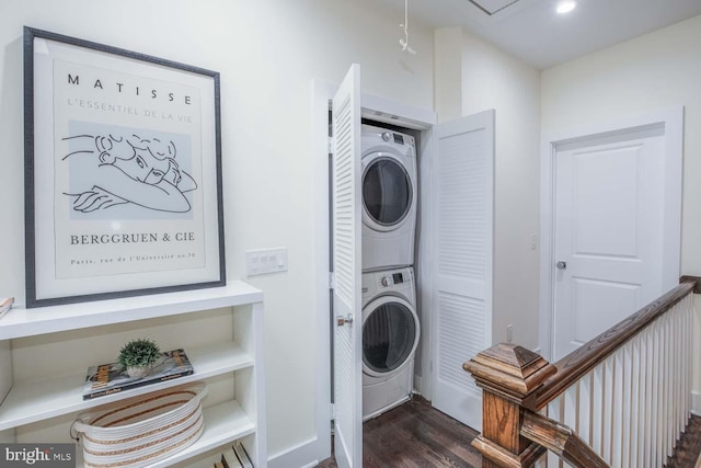 clothes washing area with stacked washing maching and dryer and dark hardwood / wood-style flooring