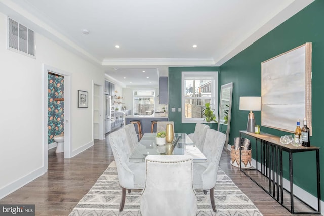 dining area with crown molding and wood-type flooring