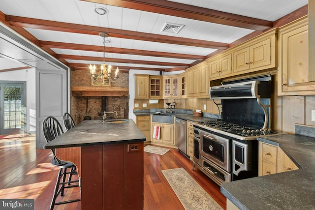 kitchen featuring dark wood-type flooring, an inviting chandelier, hanging light fixtures, beamed ceiling, and stainless steel appliances