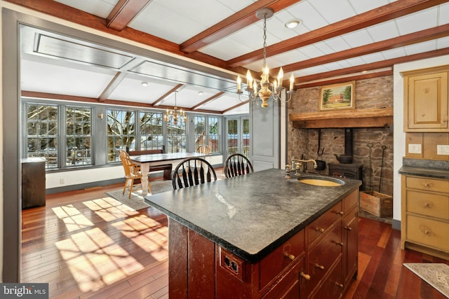 kitchen featuring a kitchen island, sink, dark hardwood / wood-style flooring, a chandelier, and hanging light fixtures