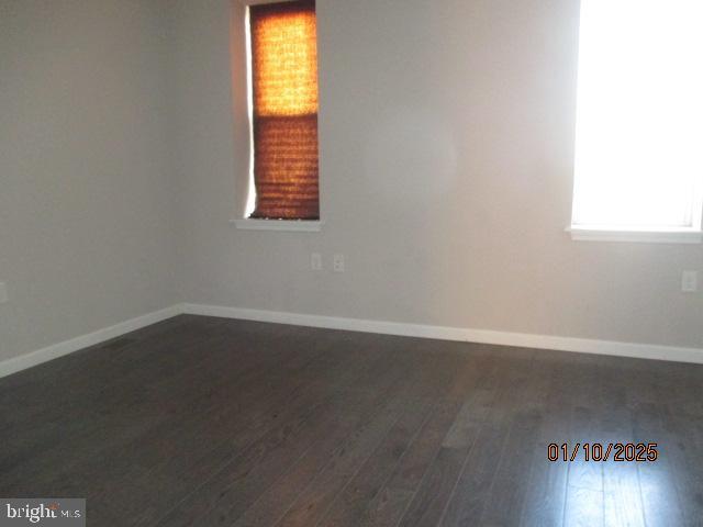 empty room with dark wood-type flooring