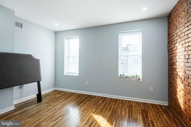 spare room featuring dark wood-type flooring and a healthy amount of sunlight