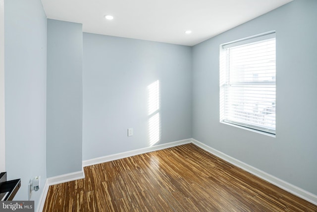 unfurnished room featuring plenty of natural light and dark hardwood / wood-style floors