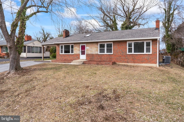 ranch-style home with central AC unit and a front lawn