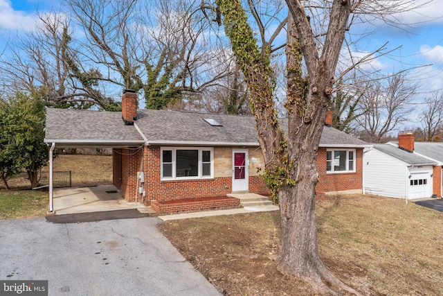 single story home featuring a front yard, a garage, and a carport