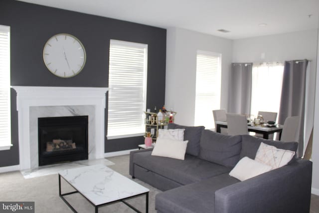 living room featuring light carpet and a high end fireplace