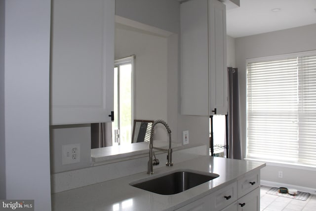 kitchen with a healthy amount of sunlight, sink, and white cabinets