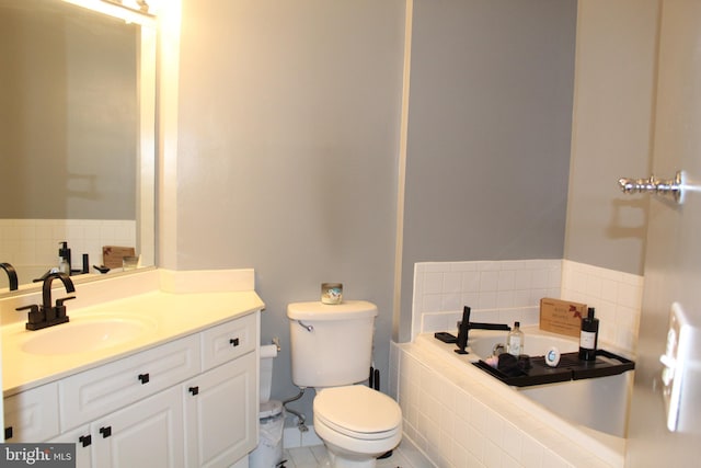 bathroom featuring vanity, a bath, and toilet