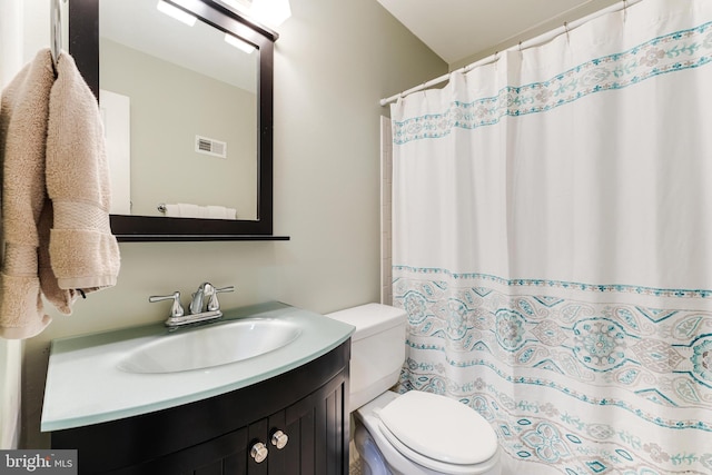 bathroom featuring a shower with curtain, vanity, and toilet