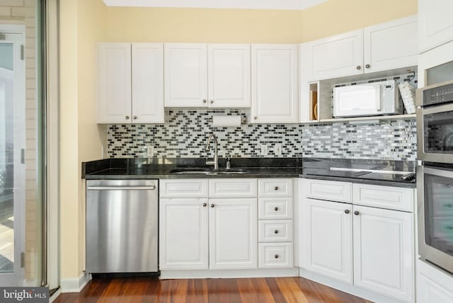 kitchen featuring sink, decorative backsplash, white cabinets, and dishwasher