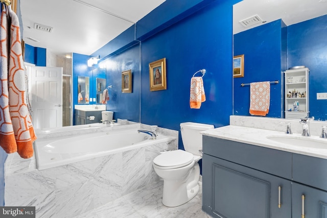 bathroom featuring vanity, tiled tub, and toilet