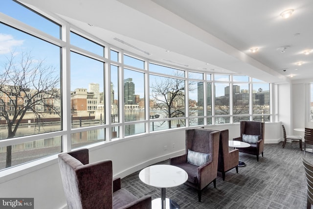 sunroom featuring a wealth of natural light and a water view