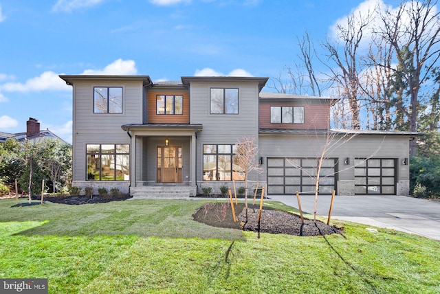 contemporary home with concrete driveway, a front yard, a standing seam roof, metal roof, and a garage