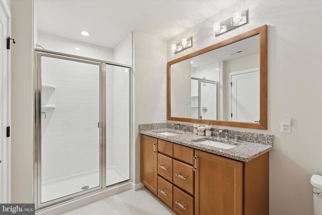 bathroom with vanity, a shower with door, and toilet