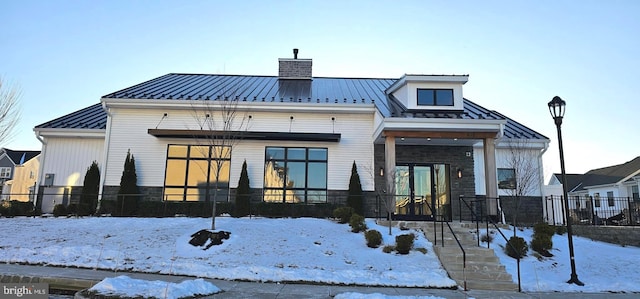 view of snow covered back of property