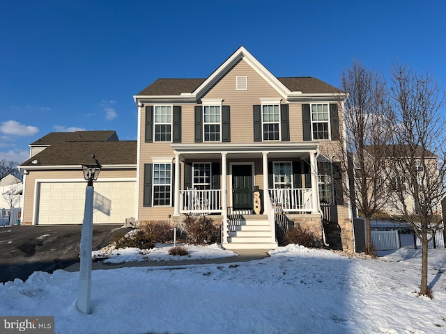 colonial house with a garage and covered porch