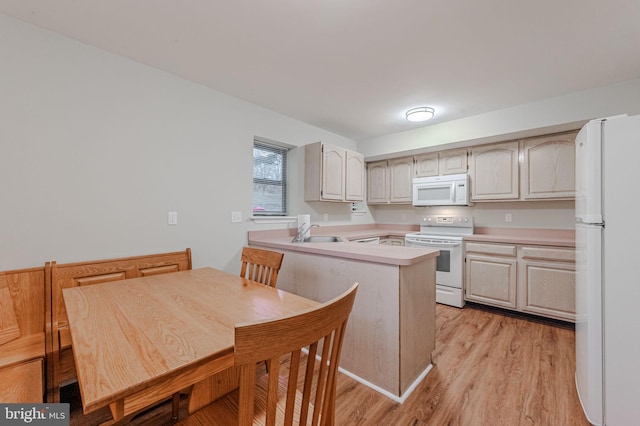 kitchen featuring white appliances, kitchen peninsula, sink, and light hardwood / wood-style flooring