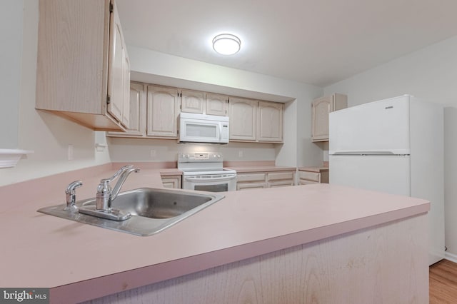 kitchen with sink, white appliances, light hardwood / wood-style flooring, and kitchen peninsula