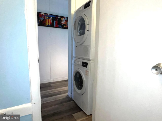 laundry room featuring stacked washer / dryer and dark hardwood / wood-style floors