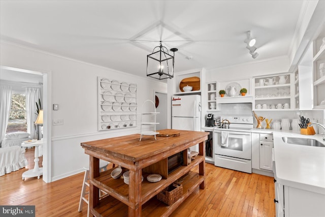 kitchen featuring sink, white cabinetry, pendant lighting, white appliances, and light hardwood / wood-style floors