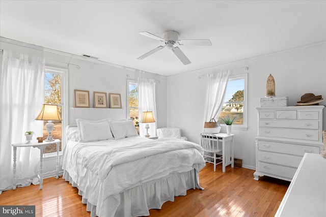 bedroom featuring multiple windows, light wood-type flooring, and ceiling fan