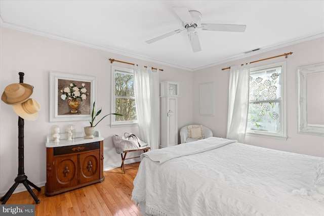 bedroom with multiple windows, ornamental molding, light hardwood / wood-style floors, and ceiling fan