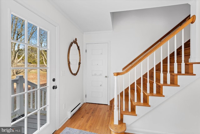 entrance foyer featuring crown molding, a baseboard radiator, and light hardwood / wood-style floors