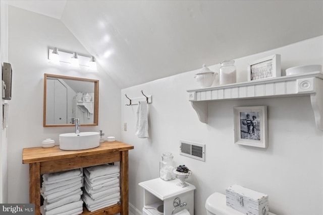 bathroom featuring vaulted ceiling, sink, and toilet