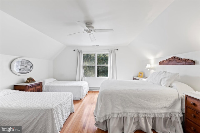 bedroom with lofted ceiling, a baseboard heating unit, ceiling fan, and light hardwood / wood-style floors