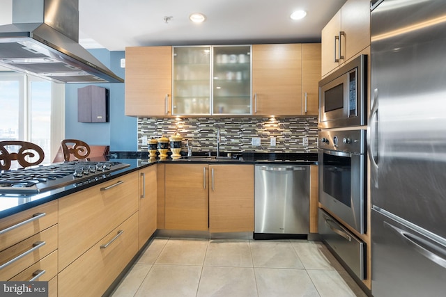 kitchen featuring light tile patterned flooring, island range hood, sink, stainless steel appliances, and light brown cabinets