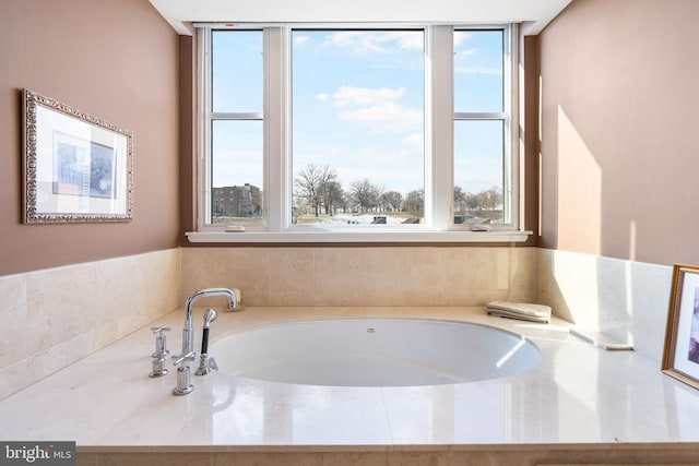 bathroom featuring a tub and a wealth of natural light