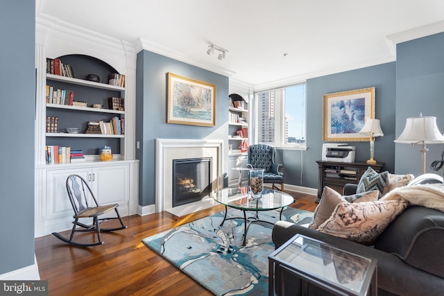 living room with crown molding, dark hardwood / wood-style flooring, and built in shelves