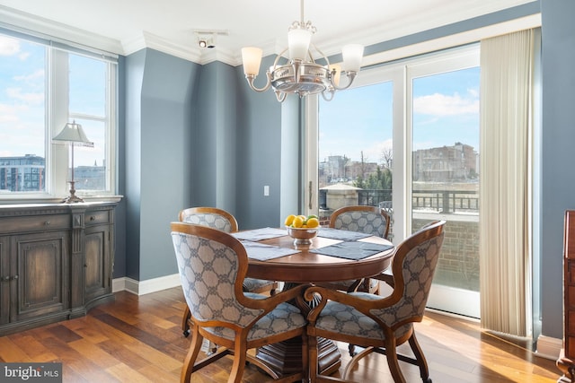 dining area with crown molding, an inviting chandelier, and light hardwood / wood-style floors