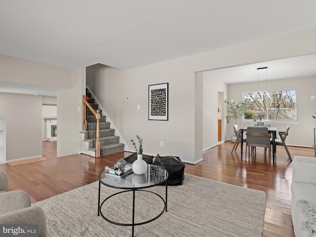 living room with hardwood / wood-style floors and a notable chandelier