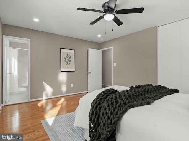 bedroom featuring connected bathroom, light hardwood / wood-style floors, and ceiling fan