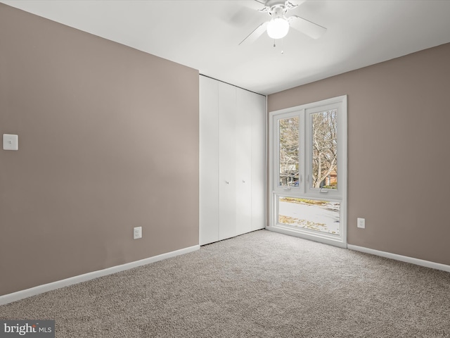 spare room featuring ceiling fan and carpet flooring