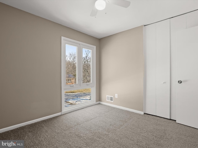 unfurnished bedroom featuring ceiling fan, carpet flooring, and a closet