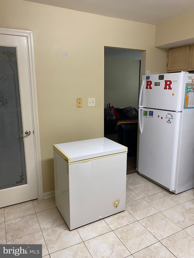 kitchen featuring white refrigerator, refrigerator, and light tile patterned floors