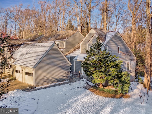 view of snow covered exterior with a garage