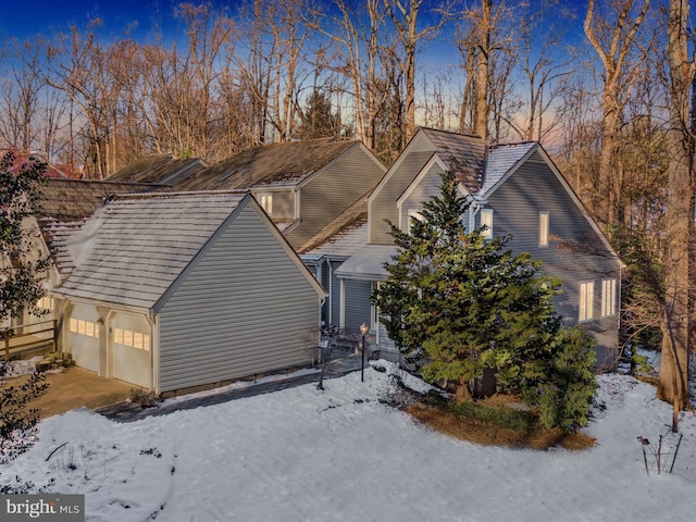 view of snowy exterior with a garage