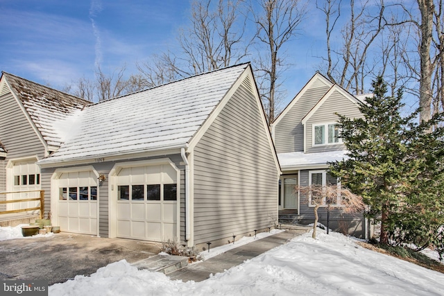 view of snow covered exterior with a garage