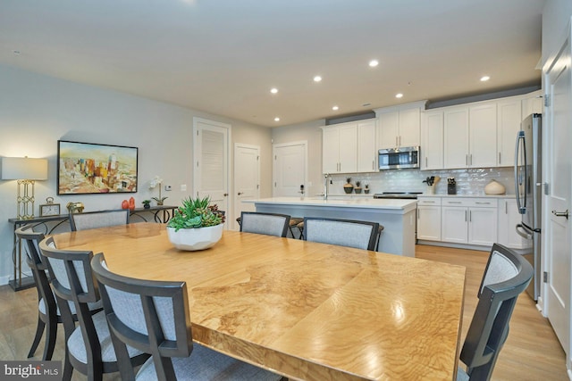 dining area with sink and light hardwood / wood-style flooring