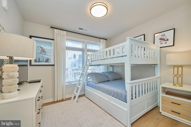 bedroom with multiple windows and light hardwood / wood-style floors