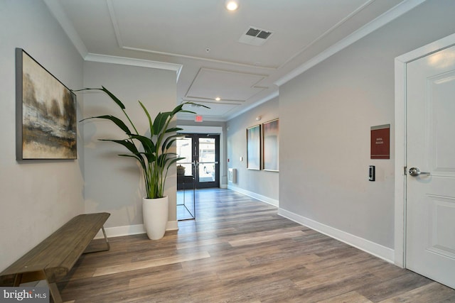 hall featuring ornamental molding, wood-type flooring, and french doors