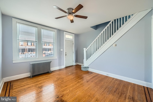 foyer featuring ceiling fan, radiator heating unit, and wood-type flooring