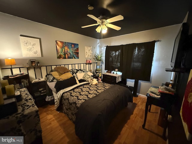 bedroom with ceiling fan and wood-type flooring