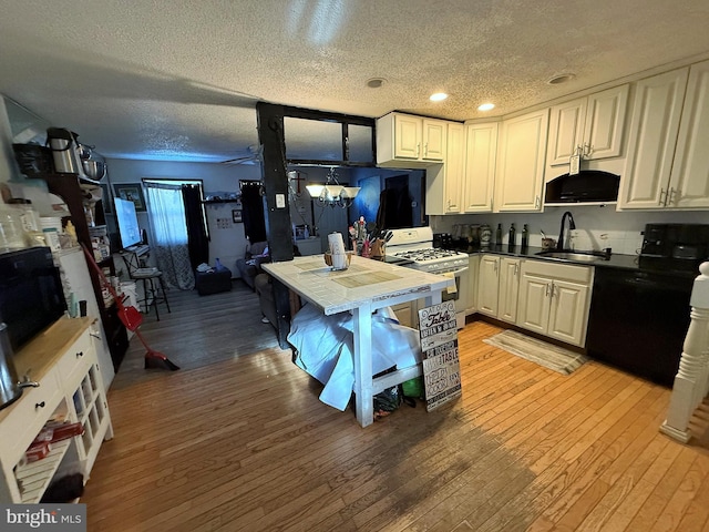 kitchen featuring sink, tile countertops, light wood-type flooring, white range with gas cooktop, and dishwasher