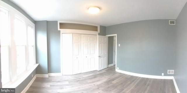 unfurnished bedroom featuring hardwood / wood-style flooring and a closet